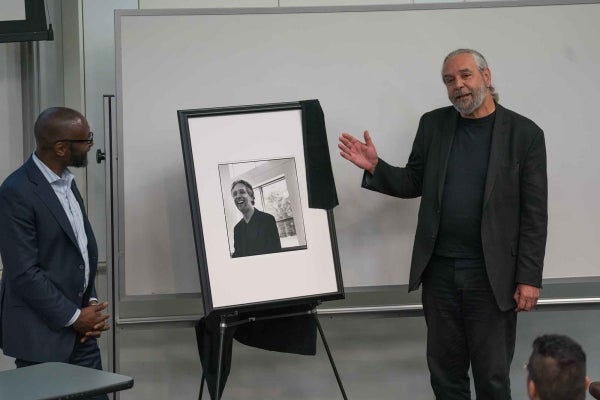Michael Delli Carpini gesturing at a portrait of himself with John Jackson looking on.