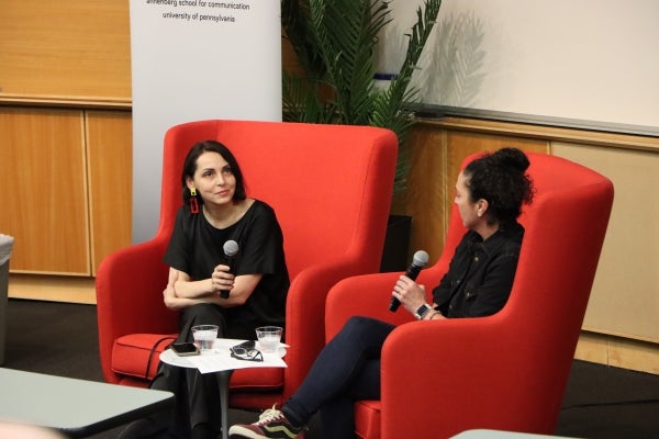 Rymma Mylenkova (left) and J.T. Blatty sit in red chairs on a stage