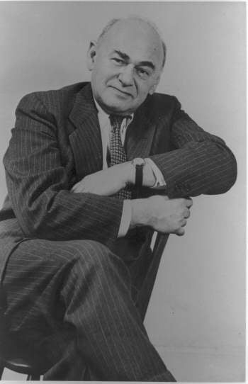 Dean Gilbert Seldes seated in a chair