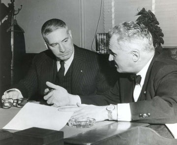 Walter Annenberg and Gaylord Harnwell seated at a table talking