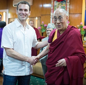 Emile Bruneau shaking hands with the Dalai Lama