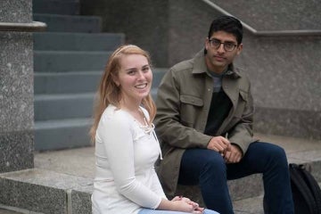 Chloe Nurik and Sanjay Jolly sitting on the Annenberg building steps
