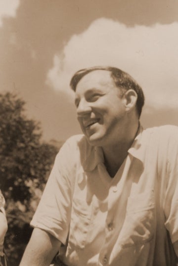Sepia tone photo of a young Elihu Katz smiling and seated outside