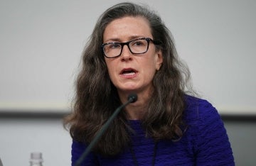 Amy Siskind behind a microphone speaking