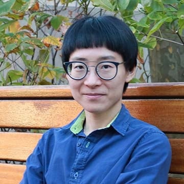 Zoe Zhou sitting on a bench outside