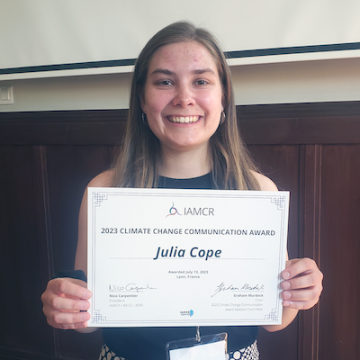 Julia Cope holds her Climate Change Communication Award certificate